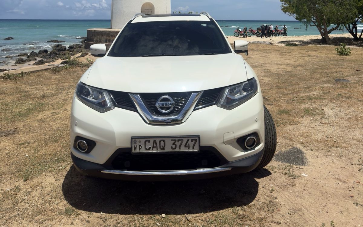 Our white Nissan X-Trail parked by a lighthouse on the coast